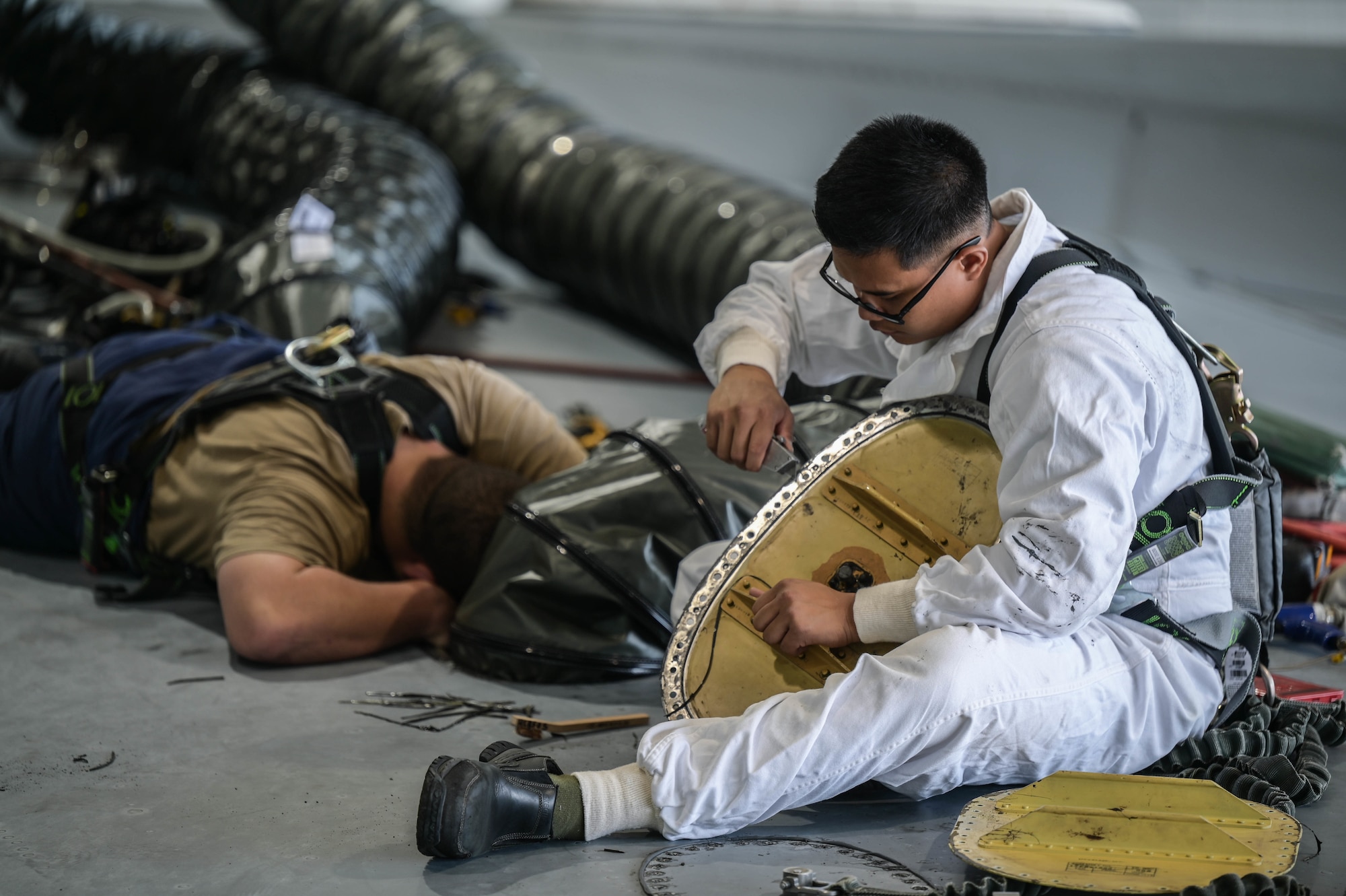 Staff Sgt. Noel Antalan, 154th Maintenance Squadron aircraft fuel systems craftsman, cleans a C-17 Globemaster III access panel during in-tank maintenance at Joint Base Pearl Harbor-Hickam, Hawaii, May 2, 2022. Fuel Airmen are assigned as entrants, attendants, or runners during in-tank maintenance in order to safely complete the procedure. (U.S. Air Force photo by Staff Sgt. Alan Ricker)