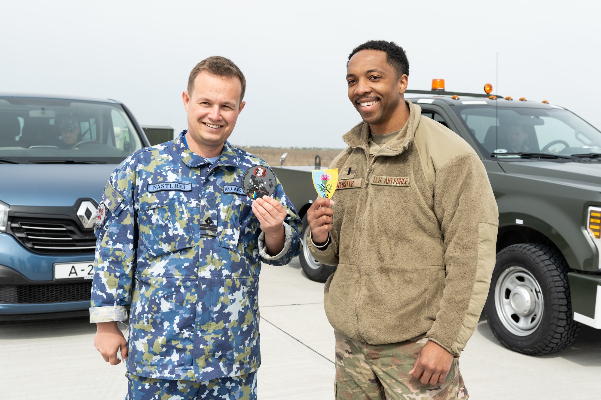 Romanian air force and U.S. Air Force lieutenants stand next to each other.