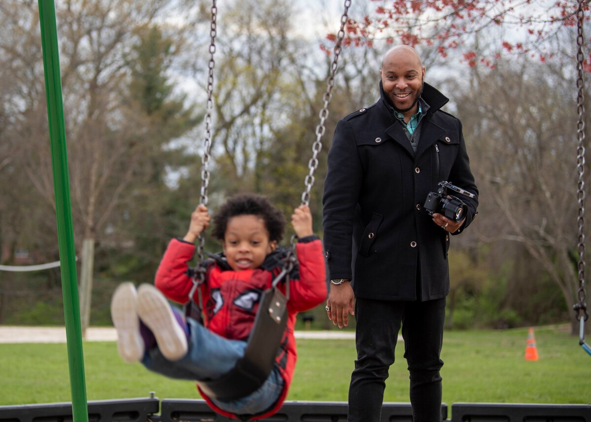 Cleveland Brown V watches his 4-year-old son, Cleveland Brown VI, swing at Silver Lake Park in Dover, Del., April 9, 2022. Brown served in the Air Force for six years and has been a military spouse for nine. (U.S. Air Force photo by Tech. Sgt. J.D. Strong II)