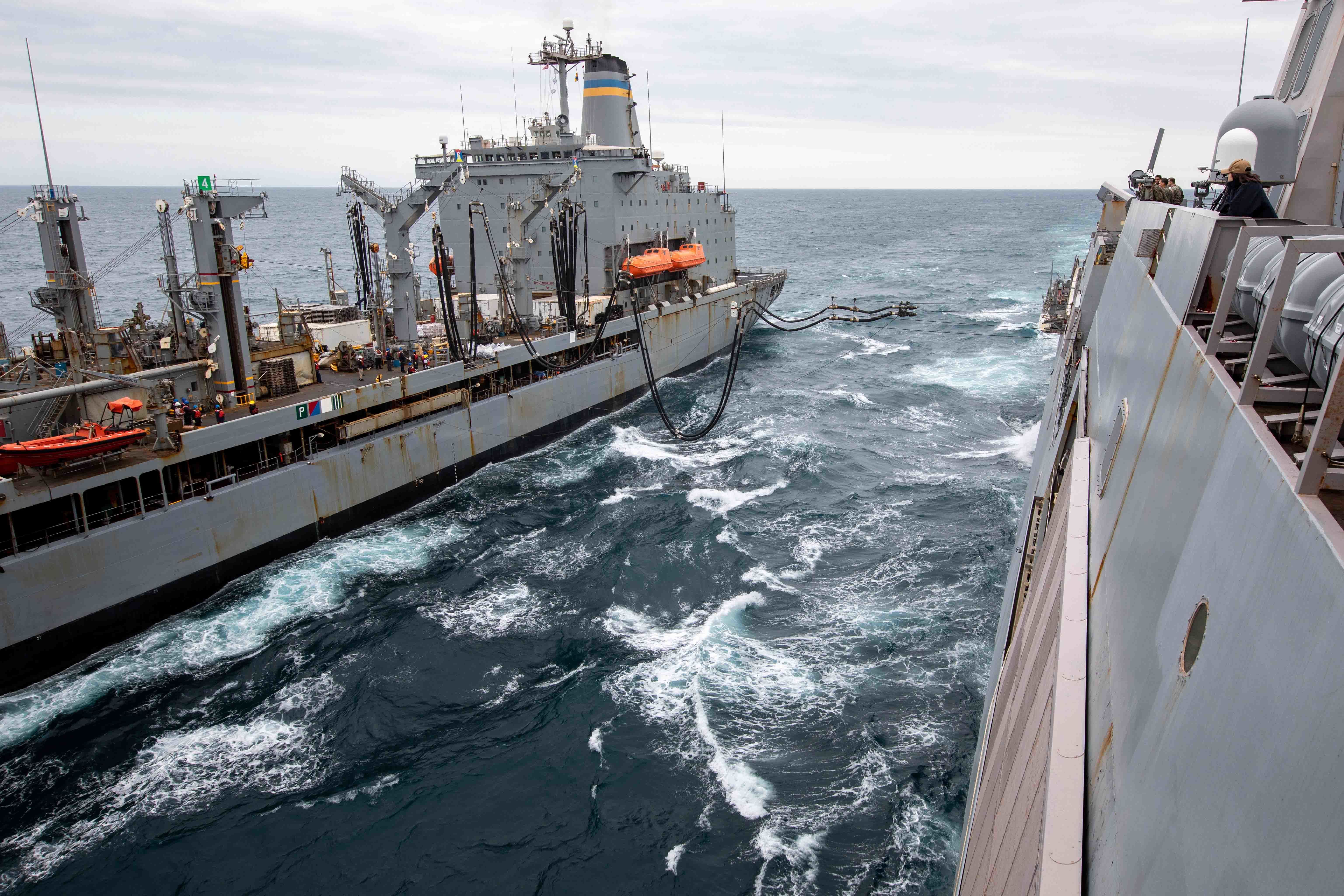 The Henry J. Kaiser-class fleet replenishment oiler USNS Patuxent (T-AO 201), left, sails alongside the San Antonio-class amphibious transport dock ship USS Arlington (LPD 24) during a replenishment-at-sea, April 23, 2022.