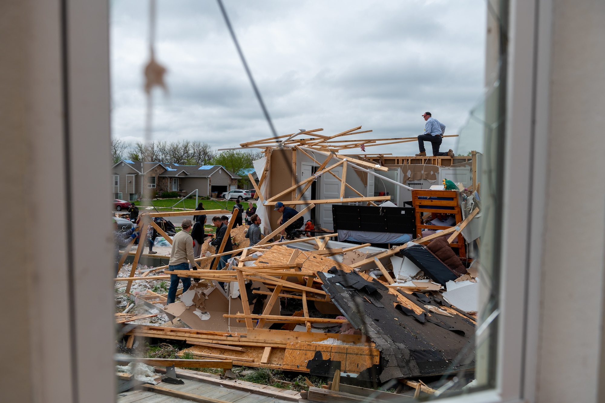 Airmen from McConnell Air Force Base, Kansas, alongside city members from Andover and communities across Kansas, clean up a damaged home May 3, 2022, in Andover, Kansas.