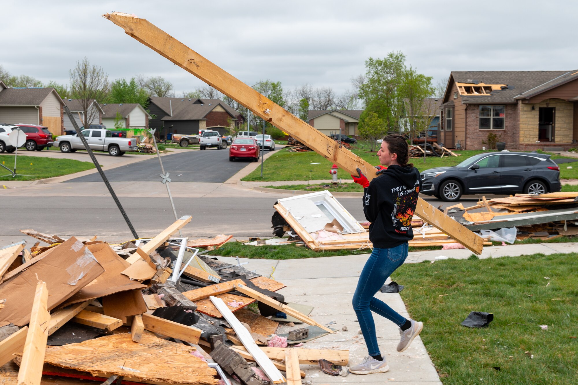 Airman Rebecca Ellison, 22nd Operational Medical Readiness Squadron dental technician, cleans up debris left by a tornado May 3, 2022, in Andover, Kansas.