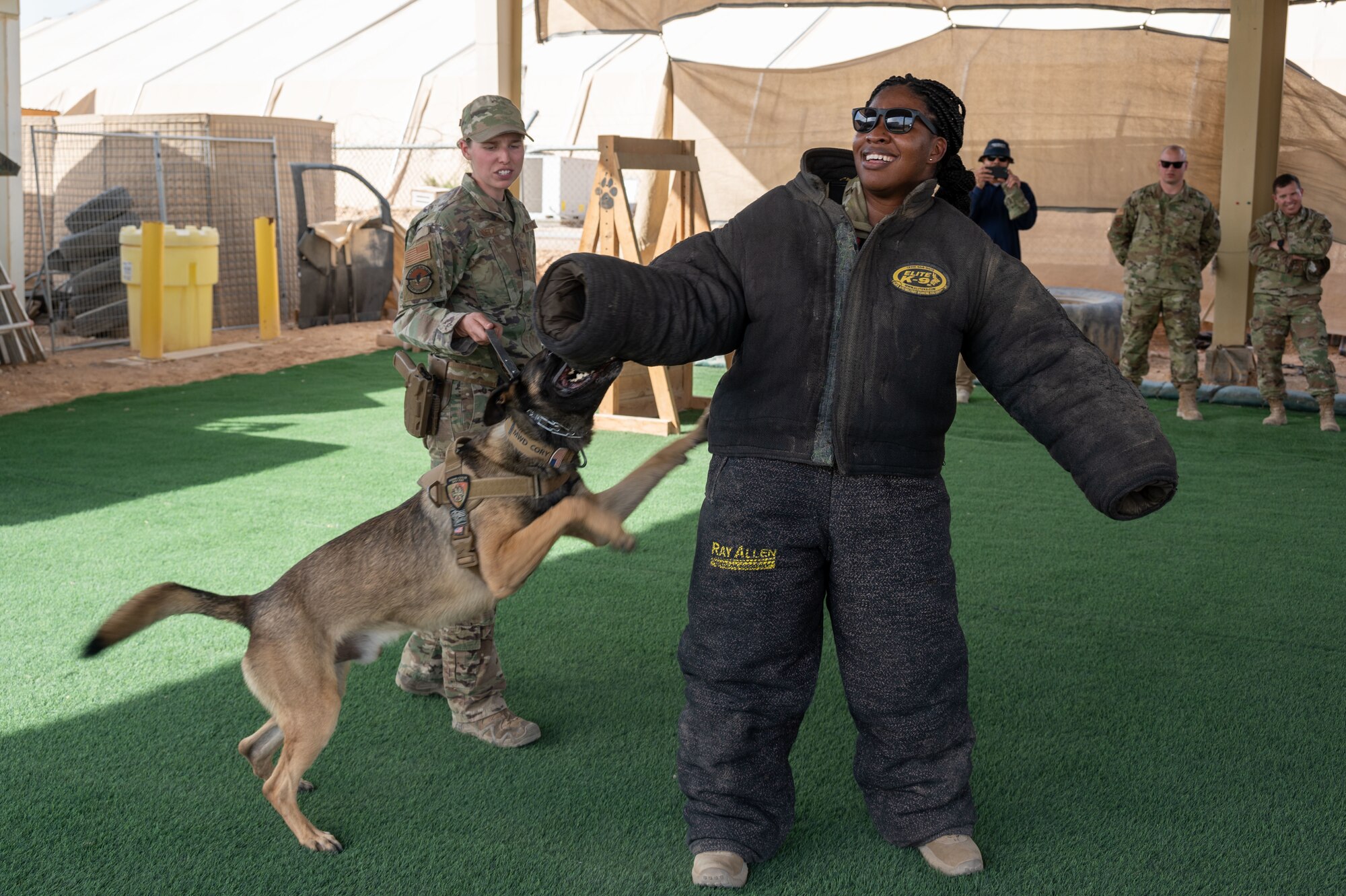 Staff Sgt. Hailey Goetz, 332d Expeditionary Security Forces Squadron military working dog handler, and her MWD, Cory, demonstrate their team’s effectiveness against a simulated perpetrator to 332d Air Expeditionary Wing Airmen at an undisclosed location in Southwest Asia, April 26, 2022. MWD demonstrations are a validation of readiness and a chance for MWDs to exercise their training. (U.S Air Force photo by Tech. Sgt. Lauren M. Snyder)