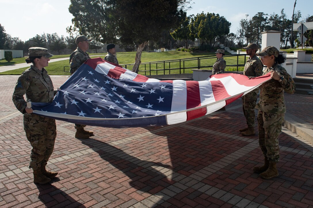 Service members fold the American flag.