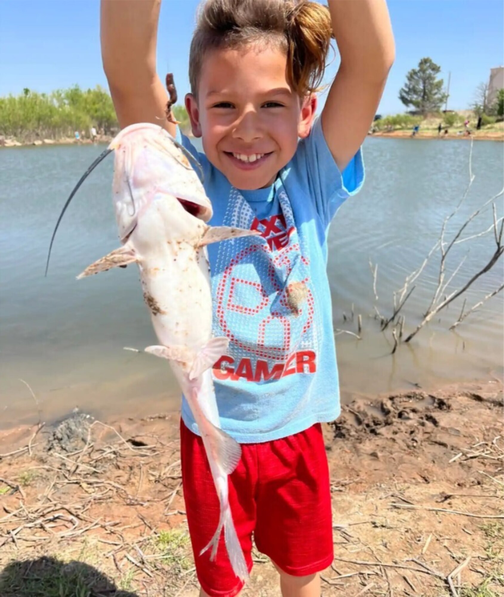 Malichi Painter holds up a recently-caught catfish at the fishing derby at Altus Air Force Base, Oklahoma, April 29, 2022. Many children were able to participate in fishing with help from family members and local game wardens. (Courtesy Photo)