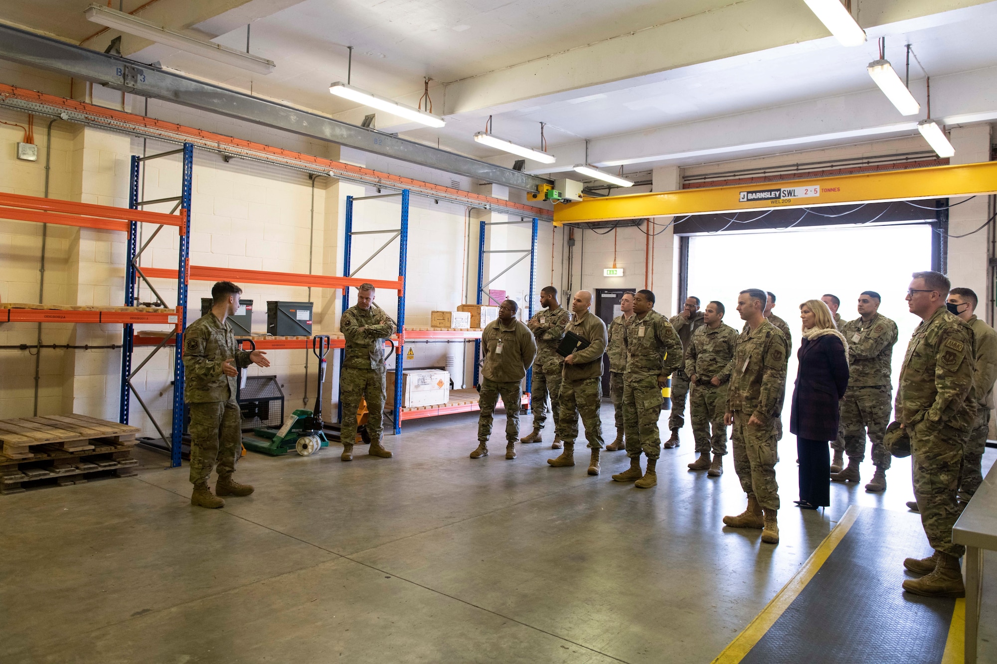 U.S. Air Force Senior Airman Nicholas Risley, left, 420th Munitions Squadron munitions inspector, briefs the 501st Combat Support Wing Readiness Working Group with the munitions inspection area at Royal Air Force Welford, England, April 27, 2022. The group attended an immersion tour at RAF Welford and RAF Fairford to orient themselves with the missions these bases provide. (U.S. Air Force photo by Senior Airman Jennifer Zima)