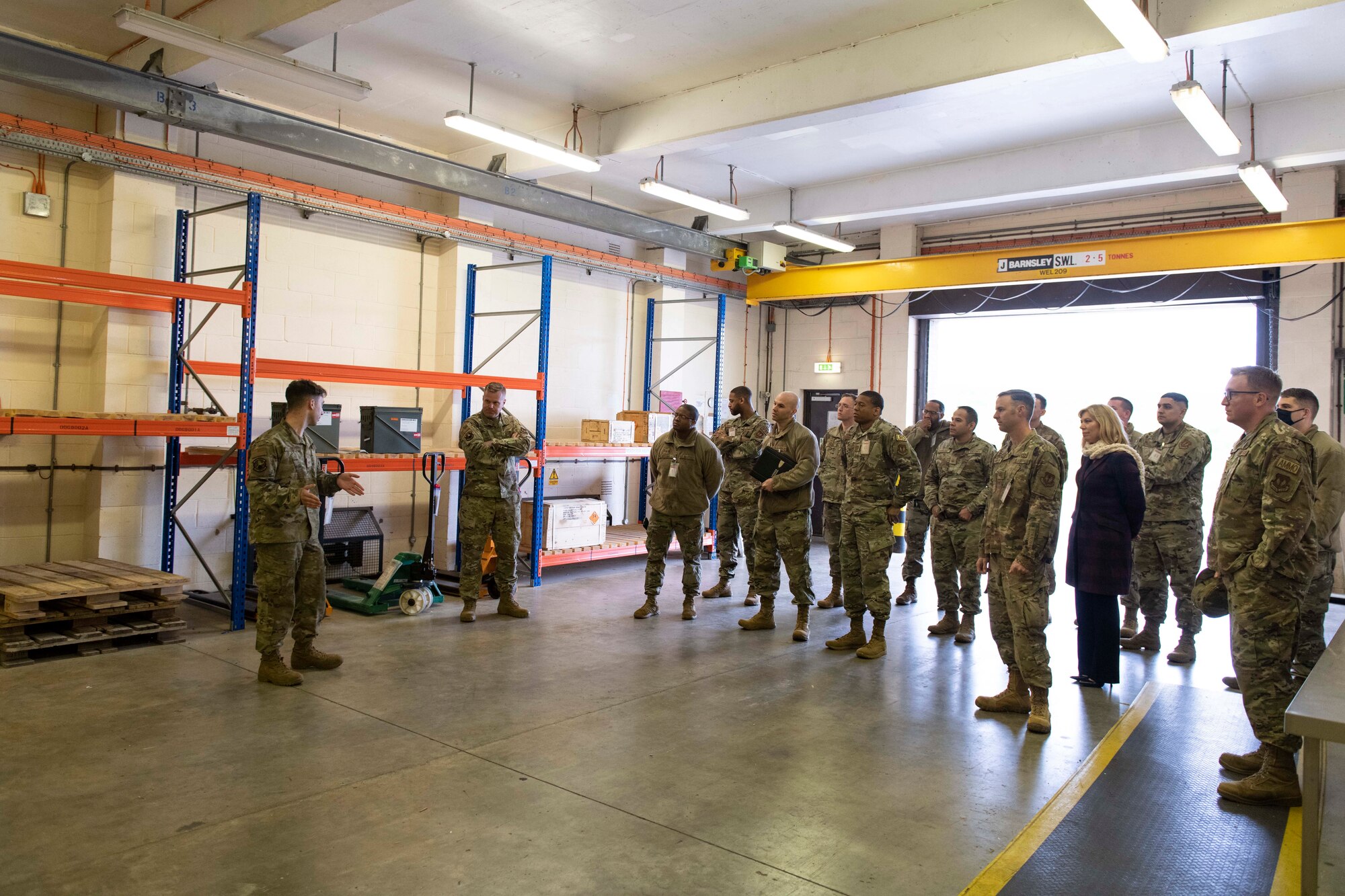 U.S. Air Force Senior Airman Nicholas Risley, left, 420th Munitions Squadron munitions inspector, briefs the 501st Combat Support Wing Readiness Working Group with the munitions inspection area at Royal Air Force Welford, England, April 27, 2022. The group attended an immersion tour at RAF Welford and RAF Fairford to orient themselves with the missions these bases provide. (U.S. Air Force photo by Senior Airman Jennifer Zima)