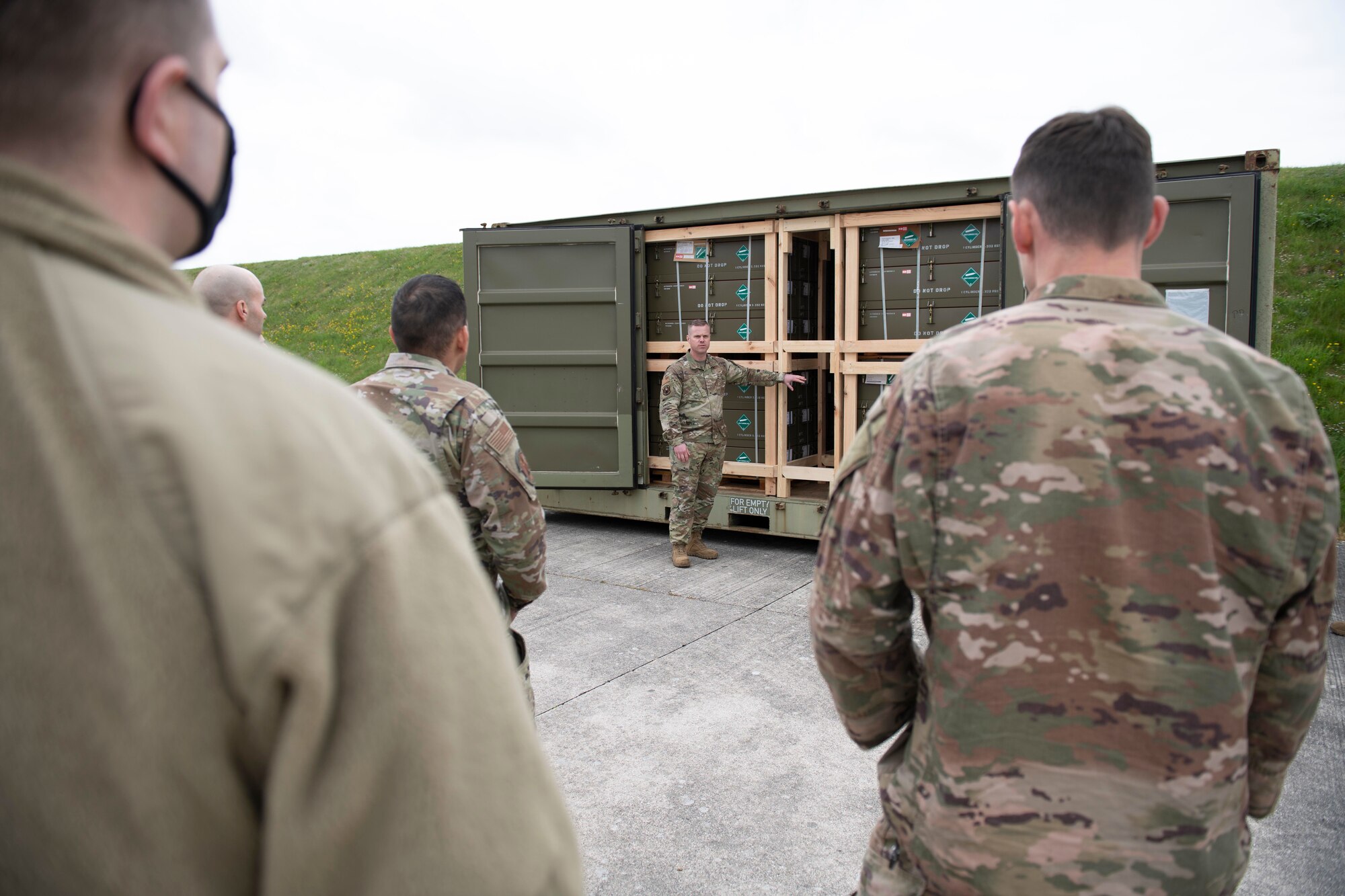 U.S. Air Force Master Sgt. Stephen Ball, center, 420th Munitions Squadron systems flight chief, briefs the 501st Combat Support Wing Readiness Working Group with the munitions inspection area at Royal Air Force Welford, England, April 27, 2022. The group attended an immersion tour at RAF Welford and RAF Fairford to orient themselves with the missions these bases provide. (U.S. Air Force photo by Senior Airman Jennifer Zima)