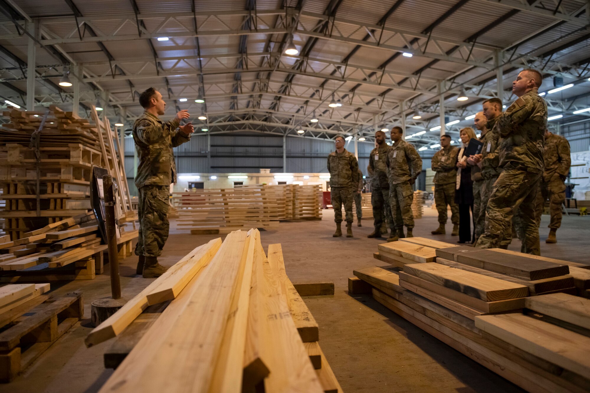 U.S. Air Force Tech. Sgt. Spenser Cox, left, 420th Munitions Squadron noncommissioned officer in charge of conventional maintenance, briefs the 501st Combat Support Wing Readiness Working Group at the munitions wood handling facility at Royal Air Force Welford, England, April 27, 2022. The group attended an immersion tour at RAF Welford and RAF Fairford to orient themselves with the missions these bases provide. (U.S. Air Force photo by Senior Airman Jennifer Zima)