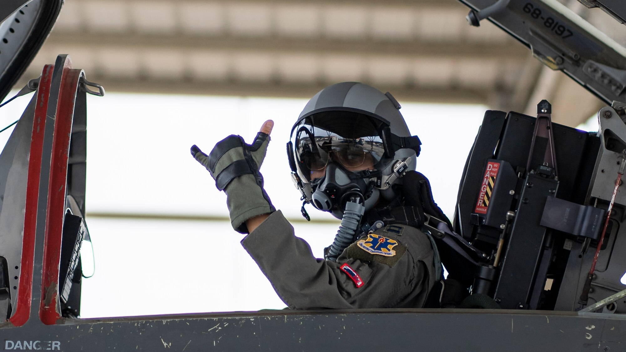 pilot in cockpit waving