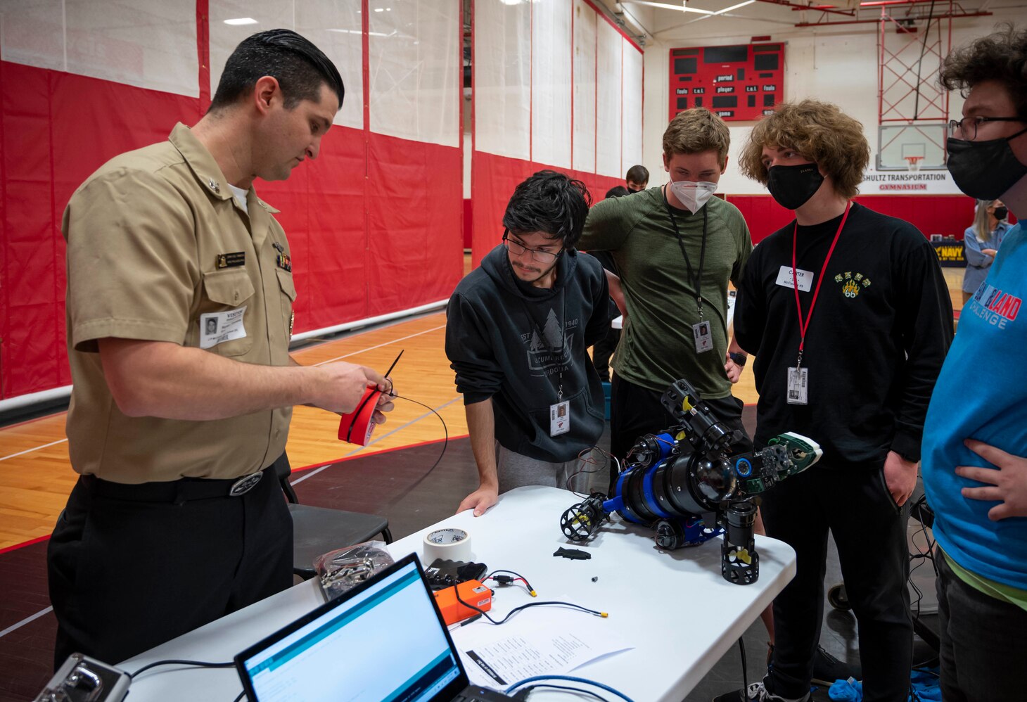 A Sailor helps J.P. McCaskey High School students resolve an issue with their submersible during the Sea, Air and Land Challenge held in Lancaster, Pennsylvania, May 4, 2022.