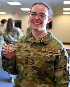 Master Sgt. Amanda Bates, program manager for the NHNG Counterdrug Task Force, shows off a coin presented to her by visiting Gen. David Hokanson, chief, National Guard Bureau, May 3, 2022, at Pease Air National Guard Base in Newington.