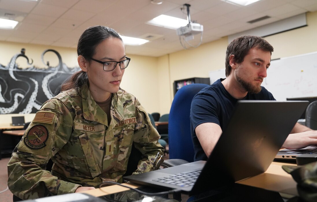 U.S. Air Force 2nd Lt. Deanna Meyer and Chris Zolnier, 333rd Training Squadron students, practice writing code in the Lovelace Lab in at Keesler Air Force Base, Mississippi, April 18, 2022. The lab was developed by students in the Undergraduate Cyber Warfare Training course to allow for more time practicing with essential software. (U.S. Air Force photo by Airman 1st Class Elizabeth Davis)