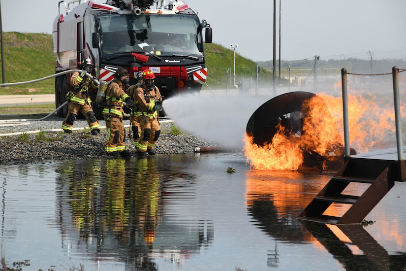 Three 316th Civil Engineer Squadron firefighters participate in a fire-fight training exercise at Joint Base Andrews, Md., May 2, 2022.