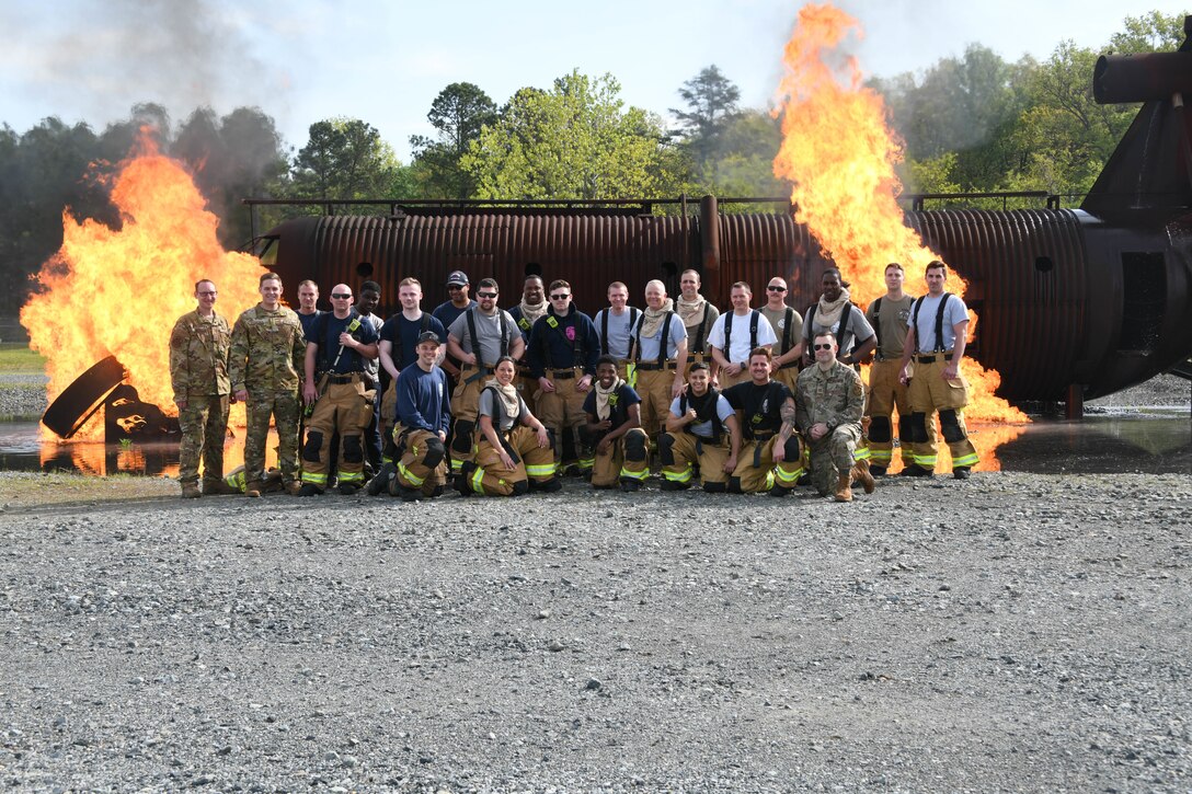 Members from the 316th Civil Engineer Squadron and 193rd Special Operations Wing pose for a group photo at a live fire-fighting training at Joint Base Andrews, Md., May 2, 2022.