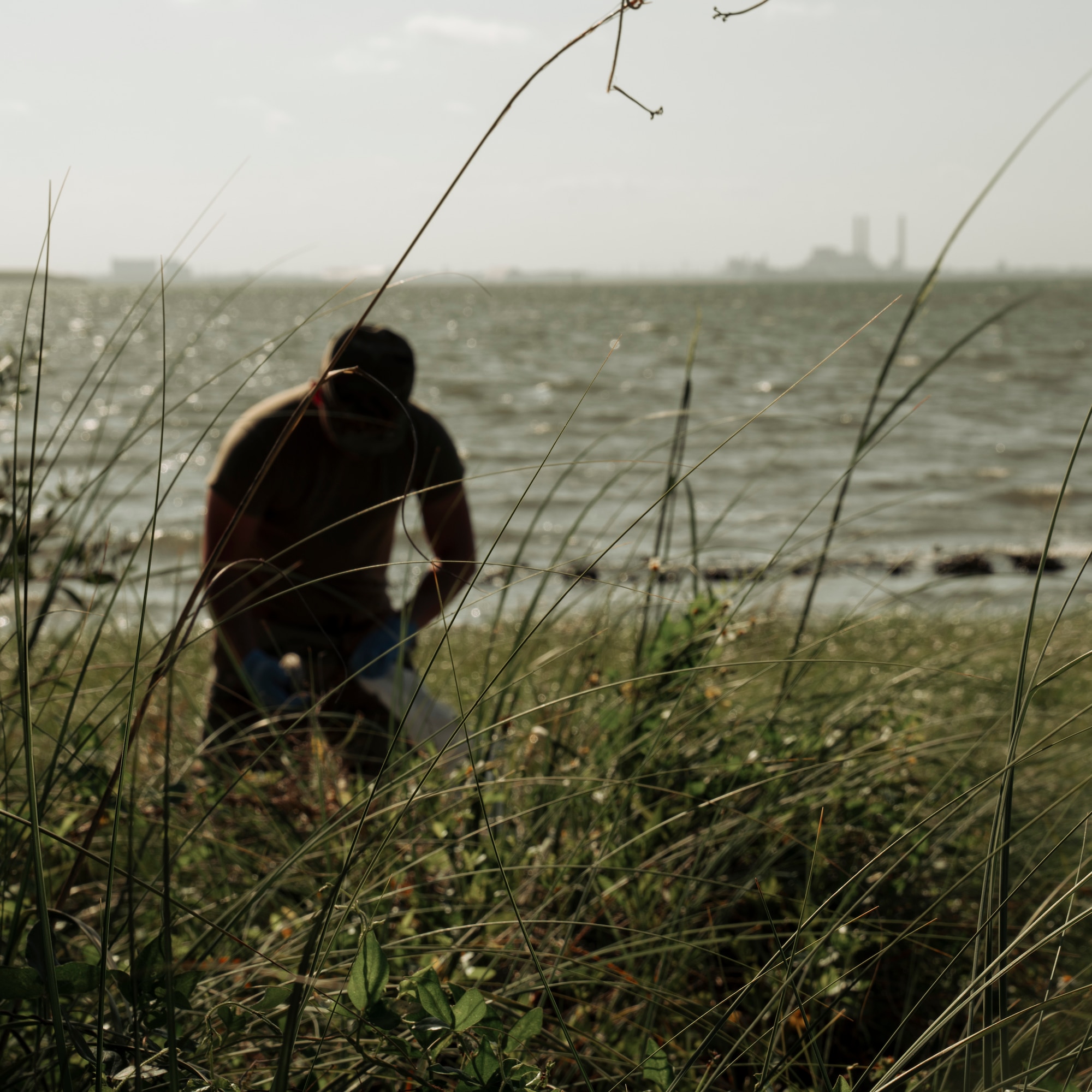 A service member picks up trash along the shoreline at MacDill Air Force Base, Florida, April 29, 2022.