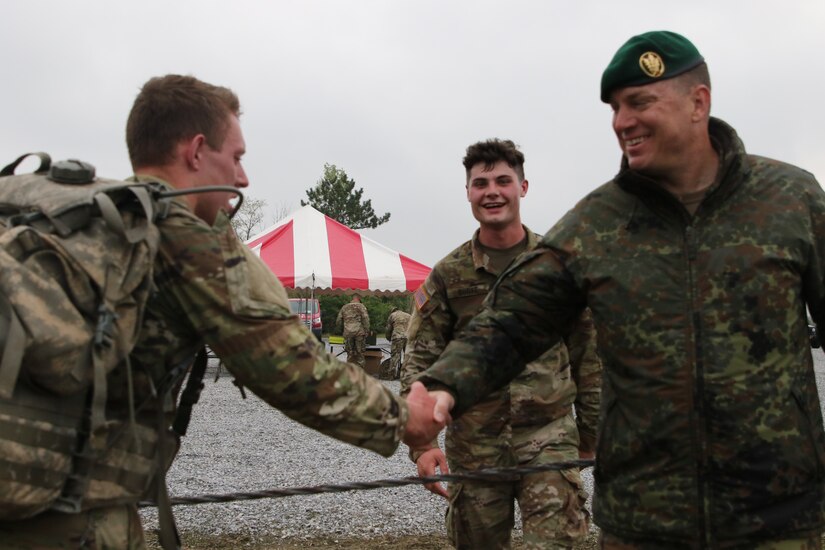 German Army Col. Karsten Kraemer, the German Army representative who officiated the event, congratulates a competitor for finishing the ruck march portion of the German Armed Forces Proficiency Badge test event at Fort Indiantown Gap, Pa. on May 3, 2022. The test, ran by the 94th Training
Division, 80th Training Command's Regional Training Site-Maintenance here, lasted three days and also included a fitness test, a pistol competition, and a swimming event.