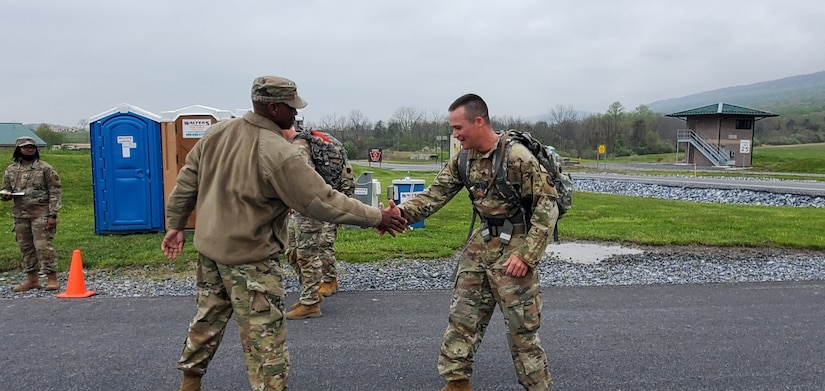 Brig. Gen. Louis Mitchell, left, the 94th Training Division's commanding general, congratulates one of his Soldiers for finishing the ruck march portion of the German Armed Forces Proficiency Badge test event at Fort Indiantown Gap, Pa. on May 3, 2022. The test, ran by the 94th Training Division, 80th Training Command's Regional Training Site-Maintenance here, lasted three days and also included a fitness test, a pistol competition, and a swimming event.
