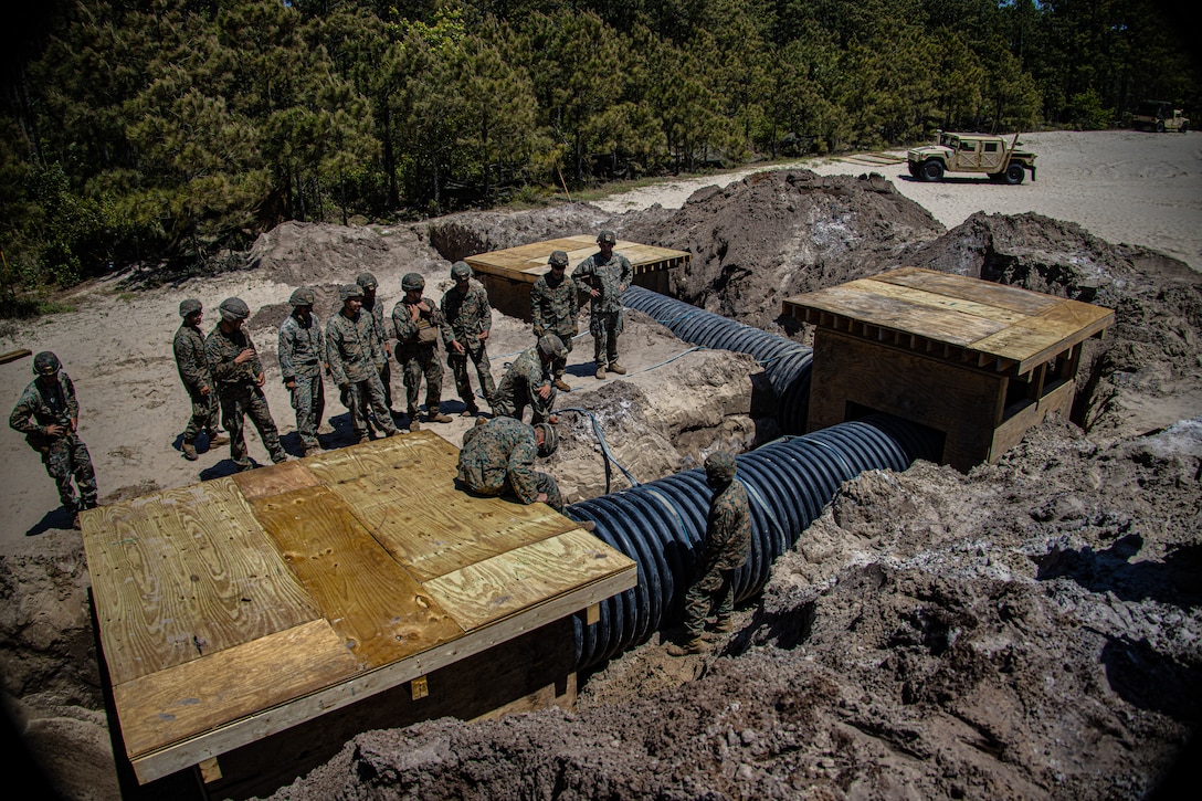 U.S. Marines with Engineer Support Company, 8th Engineer Support Battalion, complete the construction of underground bunkers during a field exercise at Camp Lejeune, N.C., April 26, 2022. Engineer Support Company conducted a field exercise in order to increase readiness while providing tactical utilities and heavy equipment support in an urban terrain environment.