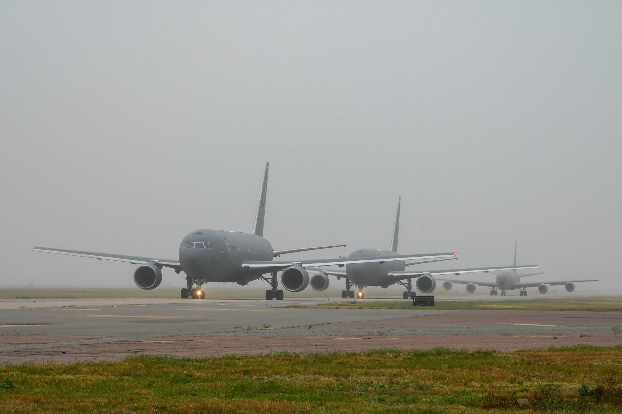 Two KC-46 Pegasus tankers and a KC-135 Stratotanker taxi on the runway due to incoming severe weather at Altus Air Force Base (AAFB), Oklahoma, May 4, 2022. 33 total aircraft launched from AAFB: 25 in a three-hour period on May 4, while 8 others took off the previous evening. (U.S. Air Force photo by Senior Airman Kayla Christenson)