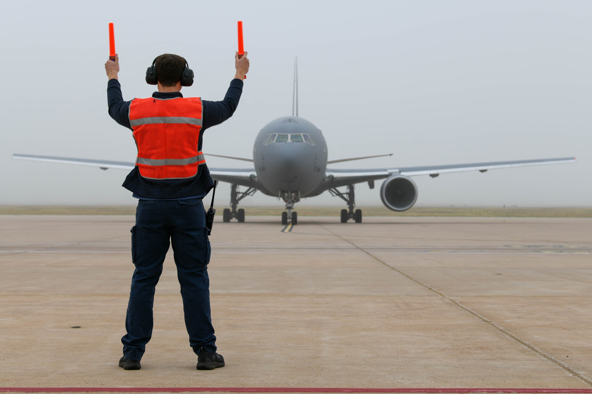 Steven Hernandez, 97th Maintenance Squadron KC-46 Pegasus crew chief, directs a KC-46 on the flight line during a severe weather flyaway at Altus Air Force Base, Oklahoma, May 4, 2022. Members of the 97th Operations Group, 97th Maintenance Group and 97th Mission Support Group worked to successfully generate and recover flights in a short amount of time. (U.S. Air Force photo by Airman 1st Class Trenton Jancze)