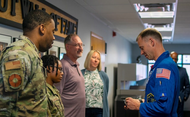 Airmen, NASA Astronaut, and civilians all pose for a photo