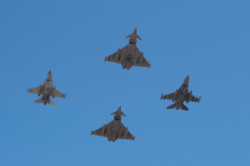 U.S., Romanian, Italian and British aircraft fly in formation.