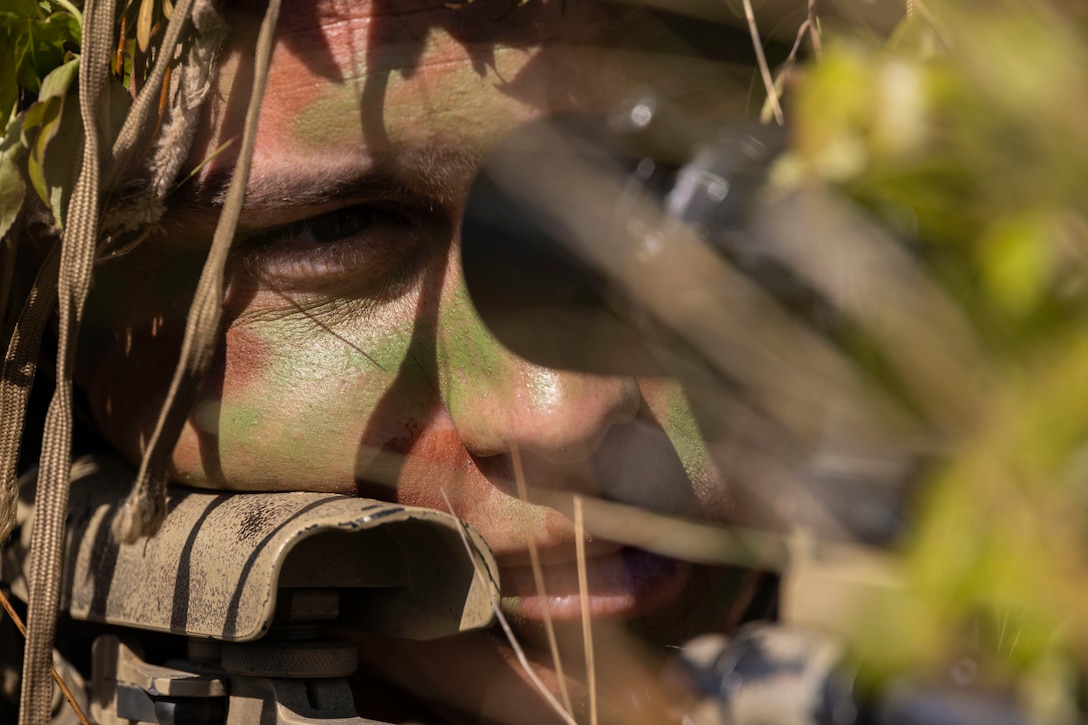 A close-up of a Marine with a weapon in camouflage.
