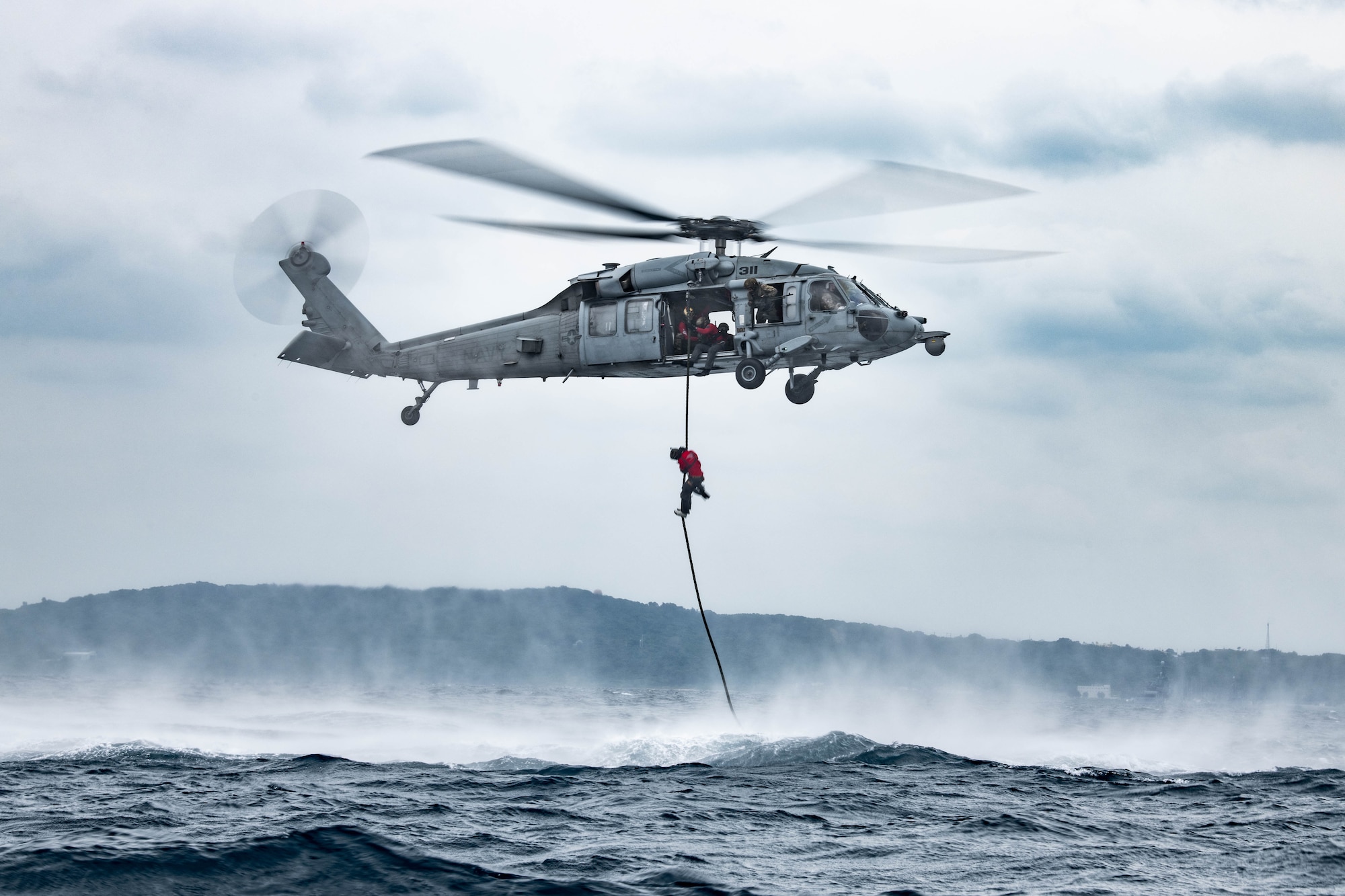 Airmen rappels form helicopter.