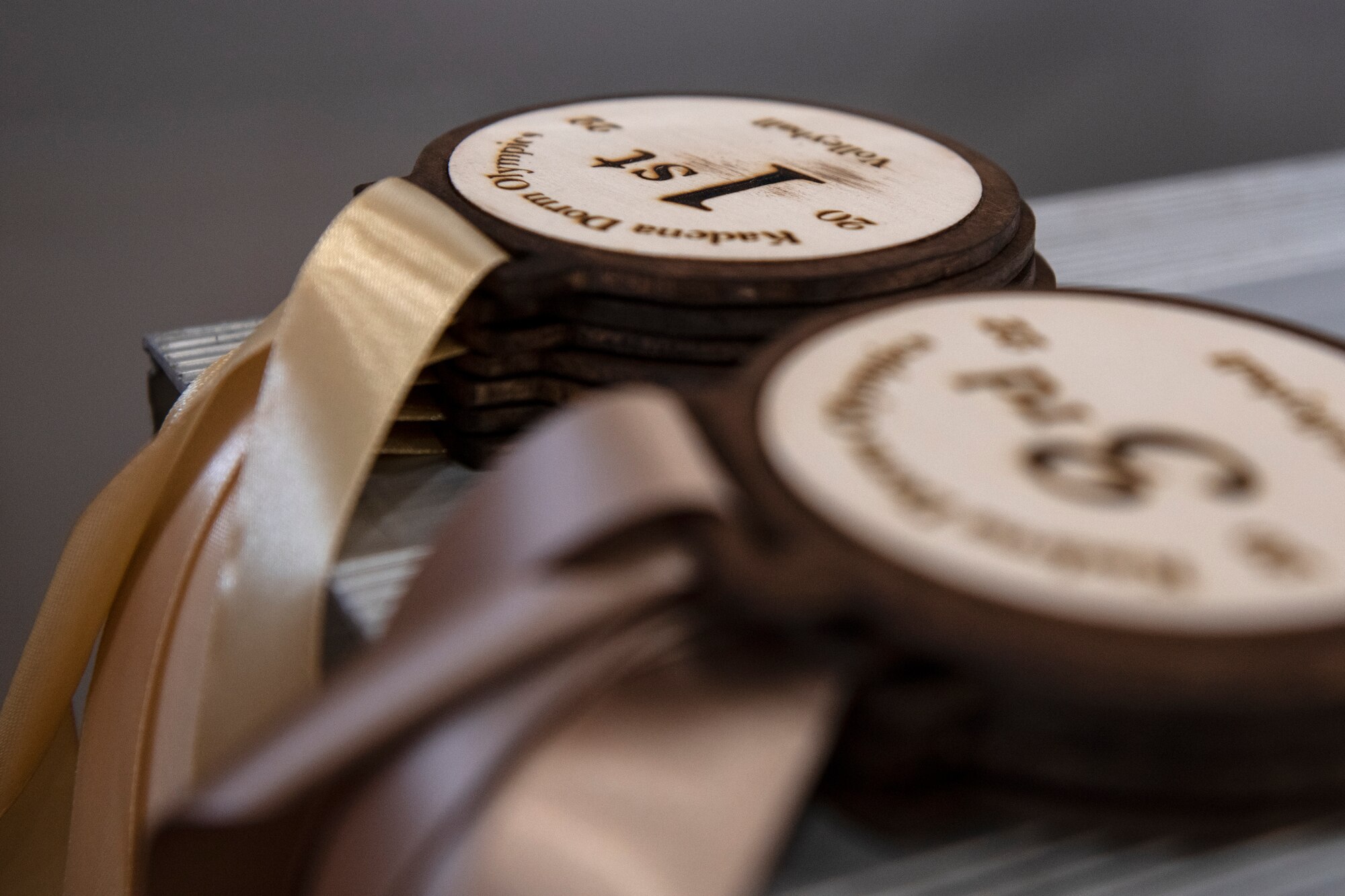 Wooden medallions were presented to winning Airmen during the first annual Dorm Olympics at Kadena Air Base, Japan, April 29, 2022. The medals were crafted and donated by the Okinawa Enlisted Spouses Club. (U.S. Air Force photo by Senior Airman Jessi Monte)