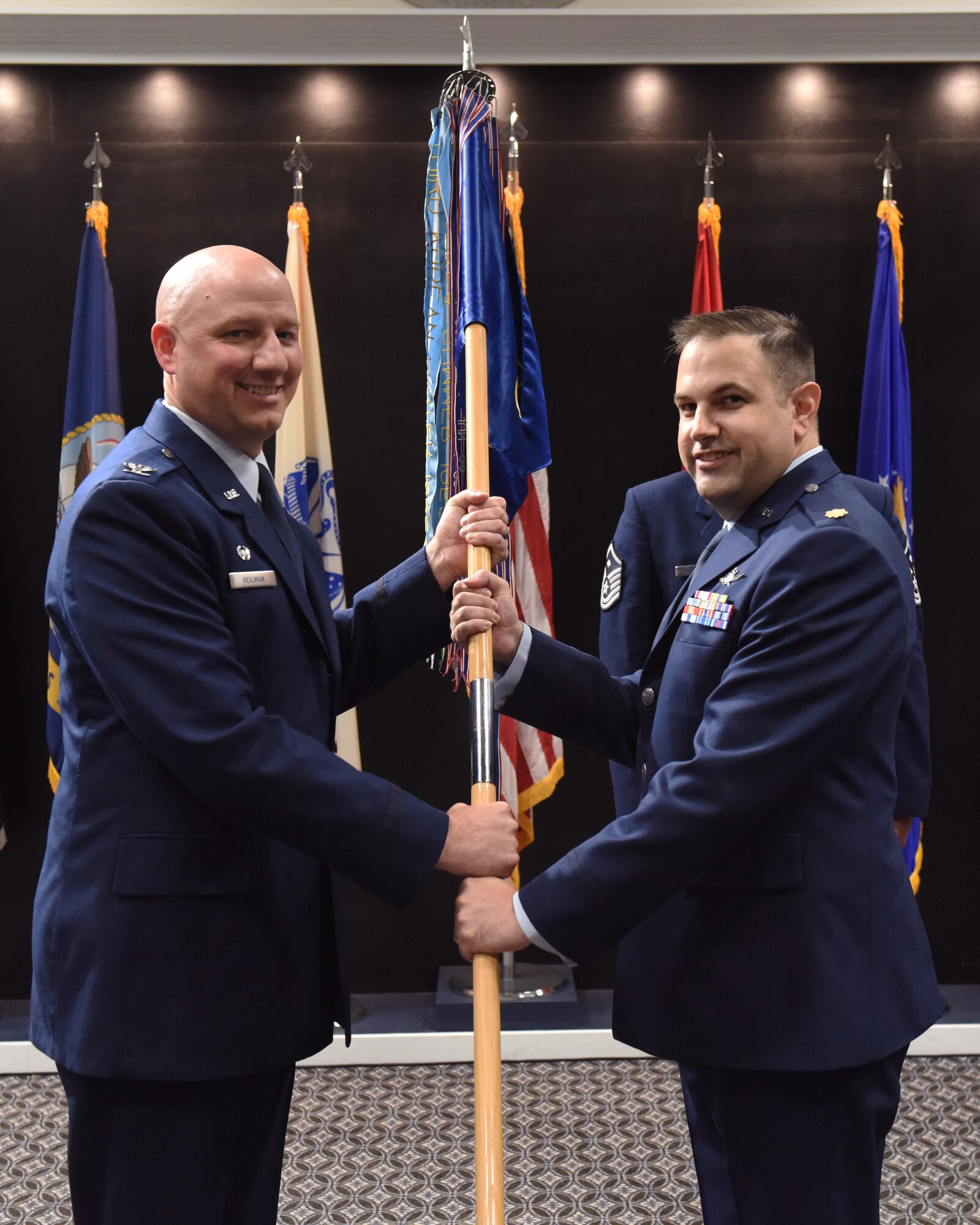 U.S. Air Force Maj. Dexter Webb (right), incoming 17th Communication Squadron commander, assumes command from Col. Matthew Reilman, 17th Training Wing commander, during the 17th CS change of command ceremony, at the Powell Event Center, Goodfellow Air Force Base, Texas, May 5, 2022.  Changes of command are a military tradition representing the transfer of responsibilities from the presiding official to the upcoming official. (U.S. Air Force photo by Airman 1st Class Zachary Heimbuch)