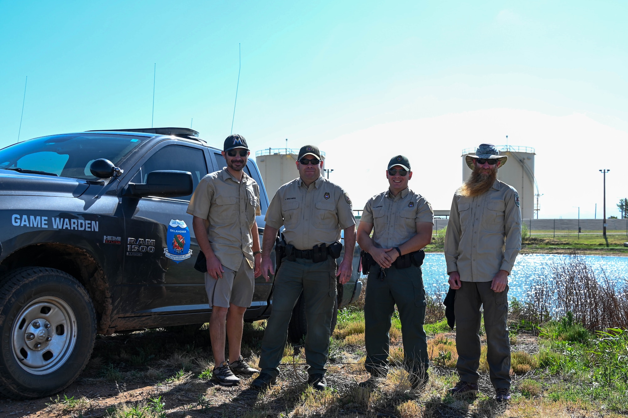 Oklahoma Department of Wildlife game wardens pose for a photo during the fishing derby at Altus Air Force Base, Oklahoma, April 29, 2022. Local game wardens provided instructional guidance on how to cast, tie knots and filet the catfish. (U.S. Air Force photo by Senior Airman Kayla Christenson)