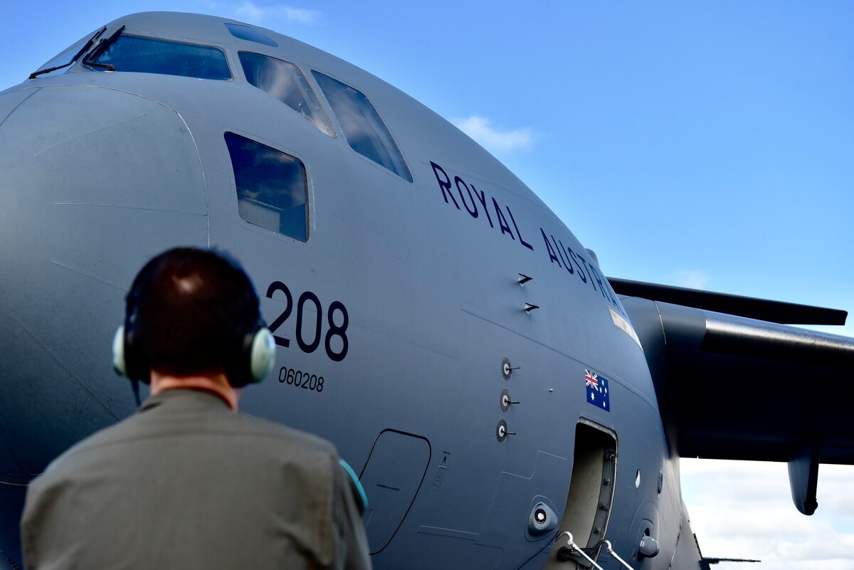 Royal Australian Air Force Corporal Grant Vaughan, No. 36 Squadron loadmaster, helps conduct a pre-flight inspection for the crew of a C-17 Globemaster III before taking off for the first training mission of Exercise Global Dexterity 2022 at Joint Base Pearl Harbor-Hickam, Hawaii, May 3, 2022. The RAF squadron visited JBPHH to join both active duty and National Guard C-17s for training missions around the Hawaiian Islands to develop tactical airlift and airdrop capabilities. (U.S. Air Force photo by 1st Lt. Benjamin Aronson)