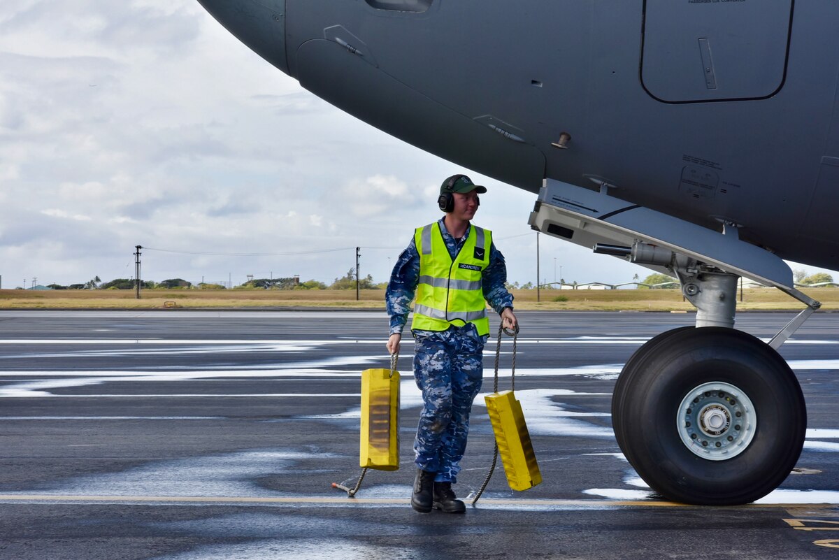 Royal Australian Air Force Leading Aircraftman Luke McAndrew, No. 36 Squadron aircraft technician, gathers the aircraft chocks of a C-17 Globemaster III before taking off for the first training mission of Exercise Global Dexterity 2022 at Joint Base Pearl Harbor-Hickam, Hawaii, May 3, 2022. Exercise Global Dexterity 2022 is designed to help develop the bilateral tactical airlift and airdrop capabilities of the U.S. Air Force and the Royal Australian Air Force. (U.S. Air Force photo by 1st Lt. Benjamin Aronson)