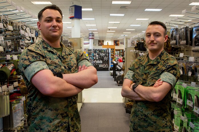 Sgts. Justin Condon and Bradley Briggs Jr., Marine Corps Community Services (MCCS) Marines with Fleet Marine Force, Atlantic, Marine Forces Command, Marine Forces Northern Command, Headquarters and Service Battalion, stand their post at the MCCS Marine Corps Exchange (MCX), Norfolk, Virginia, April 6, 2022. Condon and Briggs Jr. manage the MCX by handling the scheduling, accounting and financing of the MCX in order to keep business consistent. MCCS Marines military occupational specialty exists to support and enhance the operational readiness, war fighting capabilities, and the life quality of Marines and their families. (U.S. Marine Corps photo by Sgt. Kealii De Los Santos)