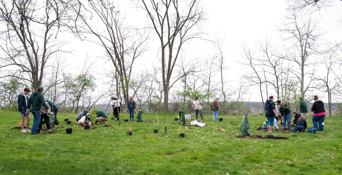 Students from the Fairborn High School Environmental Club plant trees during an Arbor Day event, April 26, 2022, at Wright-Patterson Air Force Base, Ohio. Students planted trees and bushes to create a food forest at the Wright Brothers Memorial. (U.S. Air Force photo by Jaima Fogg)