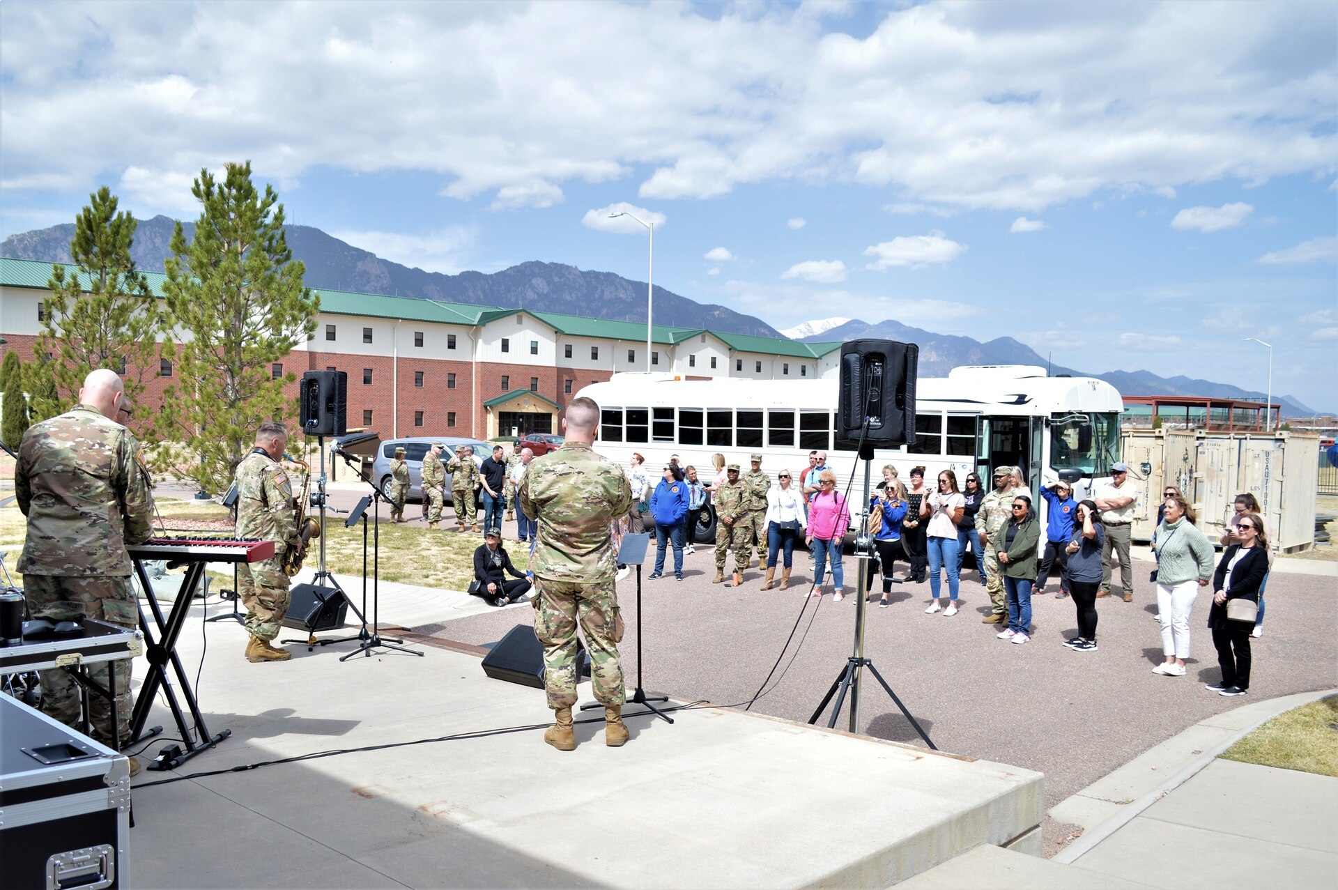 a group of people listen to band members playing music.