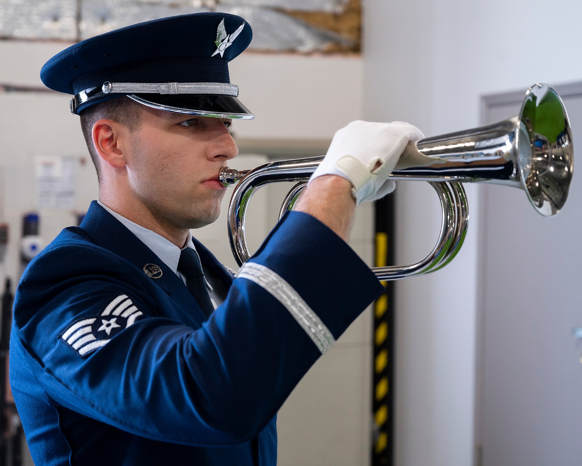 Staff Sgt. George Merusi, a new member of the Wright-Patterson Air Force Base Honor Guard, demonstrates the playing of “Taps” as part of a military funeral during the honor guard’s graduation ceremony, April 25, 2022. The bugle holds a hidden speaker that plays the music so that Airmen on six-month temporary duty do not need to learn how to play a musical instrument. (U.S. Air Force photo by R.J. Oriez)