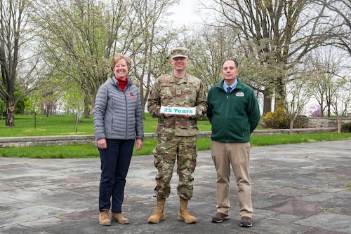 Col. Charles Barkhurst, 88th Air Base Wing vice commander, accepts a 25-years sticker from Mary Mertz and Dan Balser of the Ohio Department of Natural Resources during an Arbor Day tree planting event, April 26, 2022, at Wright-Patterson Air Force 
Base, Ohio. The stickers will be placed on signs around the base indicating its 25-year history as an Arbor Day Foundation Tree City USA.(U.S. Air Force photo by Jaima Fogg)