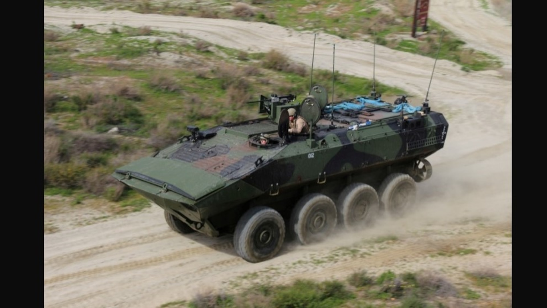 marine corps amphibious combat vehicle driving on dirt road
