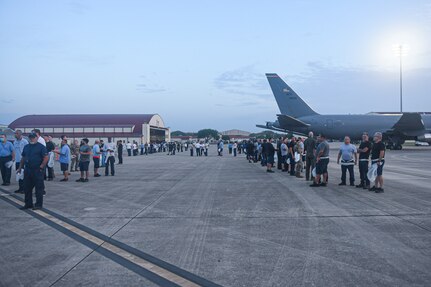 Hundreds of personnel begin lining up next to parked aircraft.