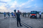 AF Civilian using bullhorn to give instructions to others lining up for a FOD walk.