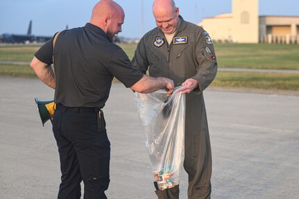 Two members collect debris on runway.