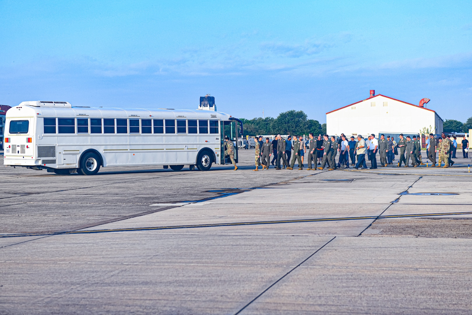 Airmen and AF Civilians board a passenger bus.