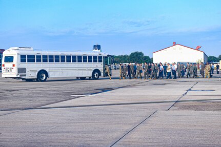 Airmen and AF Civilians board a passenger bus.