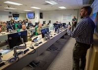 Zack Lamb, right, the Federal Emergency Management Agency Region 8 response division director, describes the capabilities of the regional response coordination center during a catastrophic incident response to Joint Task Force Civil Support Commanding General, Maj. Gen. Jeff Van, center left, and U.S. Army North Commanding General, Lt. Gen. John Evans, center, during exercise Vibrant Response 22, April 26, 2022.