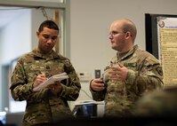 U.S. Army Capt. Gabriel Croker, left, a logistics officer assigned to the 157th Infantry Brigade, and acting as an oberserver/controller trainer during Exercise Vibrant Response 22, and Capt. Thomas Drown, the logistics officer for Joint Task Force Civil Support Incident Support Team 1, discuss concepts of sustainment for active-duty military personnel responding to a simulated nuclear detonation as part of the exercise, April 27, 2022.