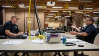 Kevin Woodrum, left, and Hans Lageschulte, both exercise planners assigned to Joint Task Force Civil Support, discuss the Vibrant Response 22 Exercise, April 28, 2022.