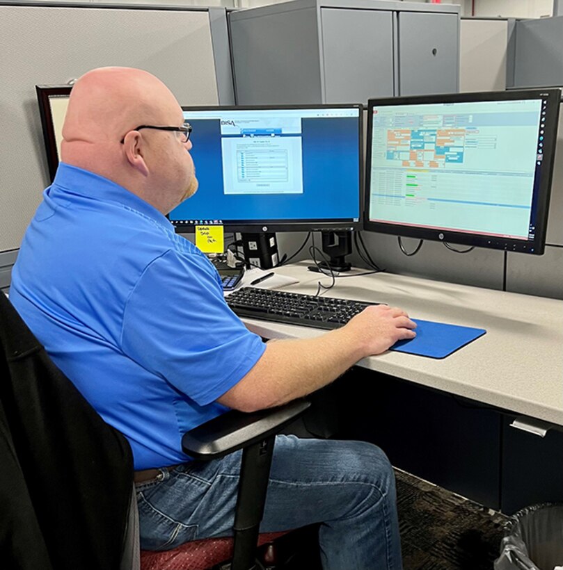 Scott Wilkerson at his desk using the Local Retail Buy Request and Tracking System database.