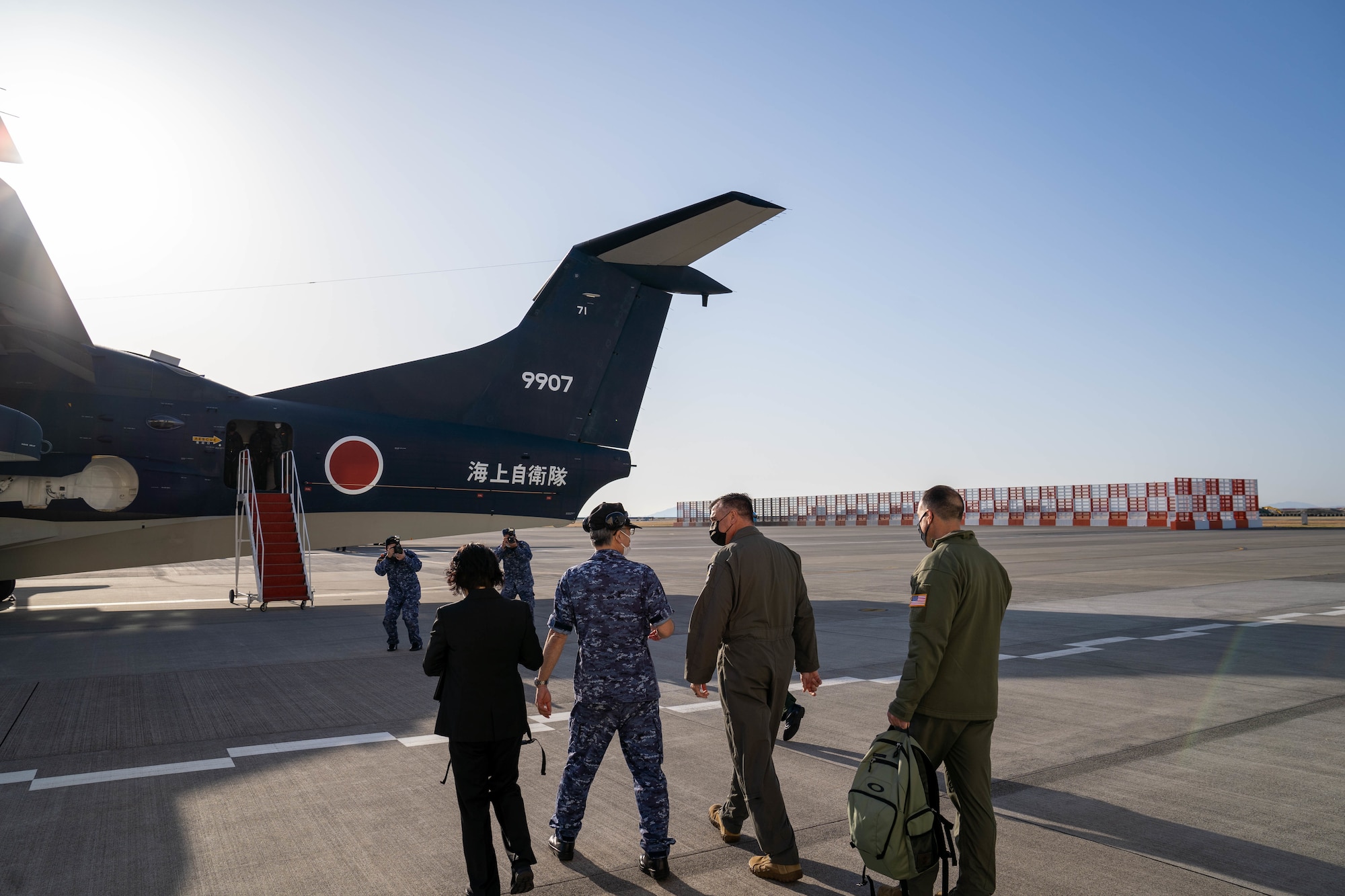U.S. Air Force Maj. Gen. Eric Hill, deputy commander of Air Force Special Operations Command, center right, and Maj. Gen. Leonard Kosinski, 5th Air Force deputy commander, far right, board a ShinMaywa US-2 assigned to the Japanese Maritime Self-Defense Force's Air Patrol Squadron 71 at Marines Corps Air Station Iwakuni, Japan, April 5, 2022. During the visit the generals were able to witness the unique search, rescue, and personnel recovery capabilities the amphibious aircraft delivers firsthand. (U.S. Air Force photo by Capt. Joshua Thompson)